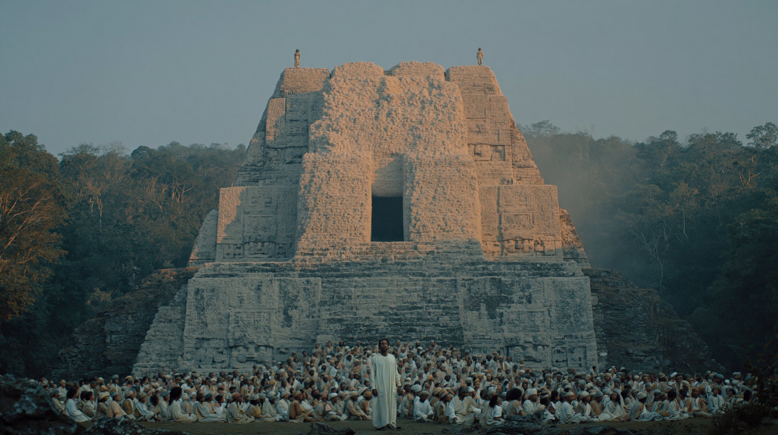 An alternate stone temple rises above a gathering dressed in pale ceremonial garments at the edge of the jungle.