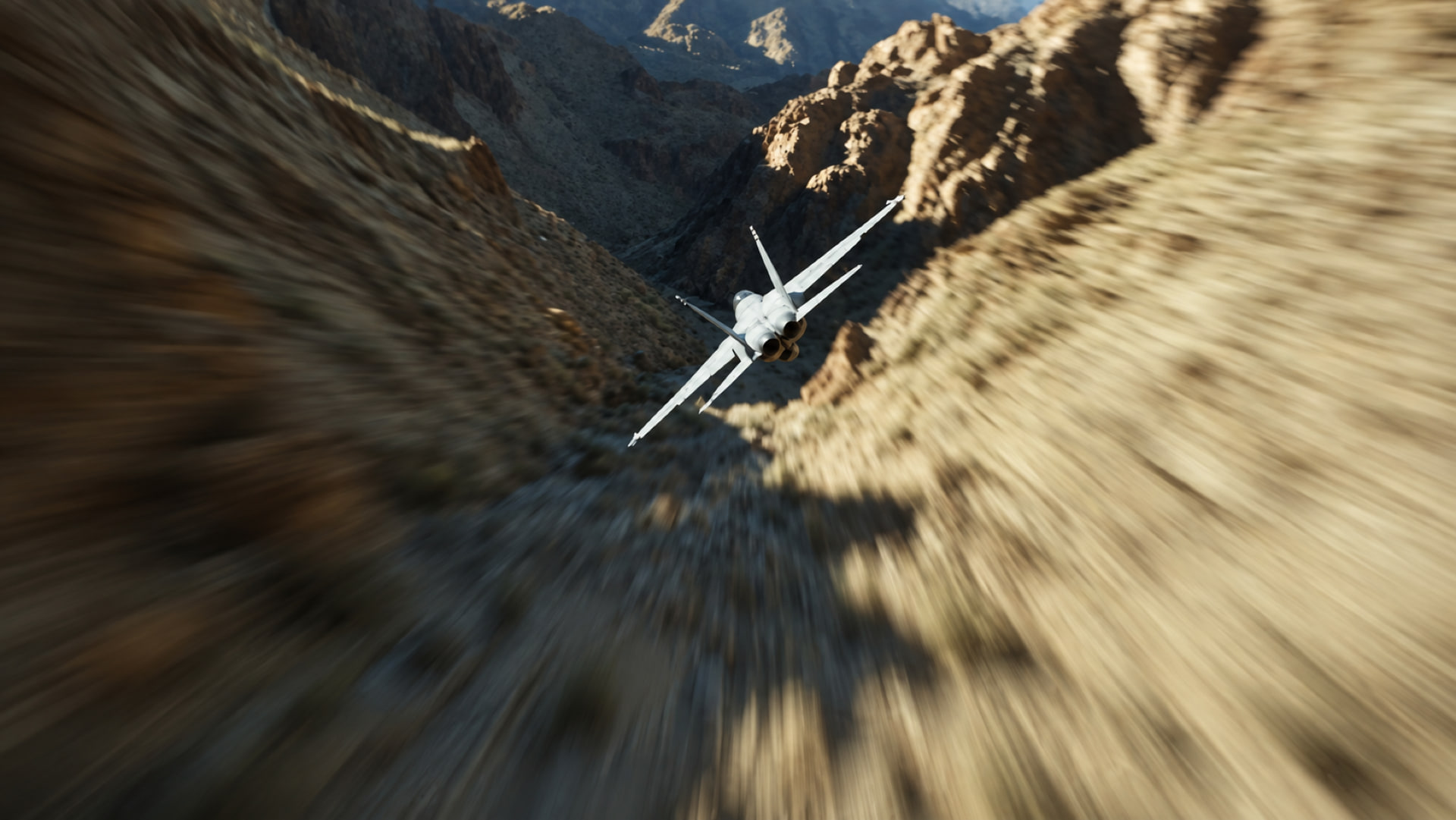 A fighter jet banks through a sunlit desert canyon, the rock walls streaking with motion blur.